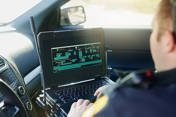 Image of a police officer working on a laptop.